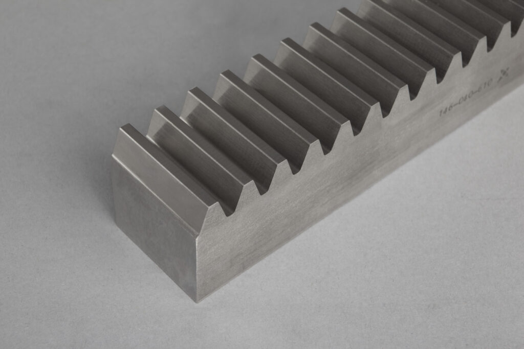 Unser Sortiment umfasst gerad- und schrägverzahnte Zahnstangen in geschliffener sowie gefräster Ausführung. Wir fertigen sowohl Standards als auch Sonderlösungen in diversen Modulen, Abmessungen und Werkstoffen, auch gehärtet und beschichtet.